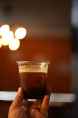 a cup of ice coffee on the wood table