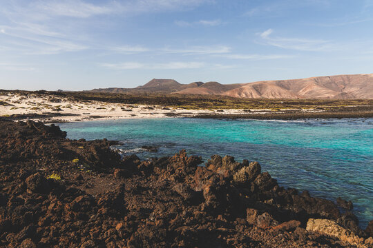 Lanzarote landscape with beautiful blue beach and volcanic rocks