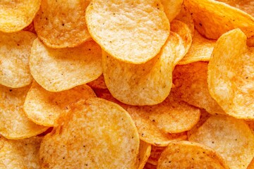 Top view of a pile of crispy golden kettle chips, crunchy texture, snack food background