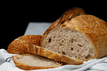 Traditional wheat freshly baked rustic bread on a towel. Artisan sourdough bread