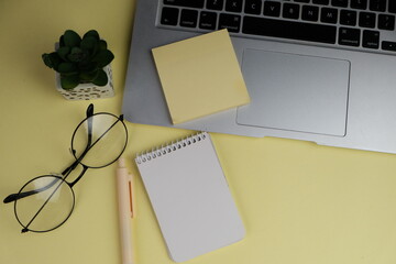 Home office workspace mockup with laptop, clipboard, palm leaf, notebook and accessories. Flat lay,...