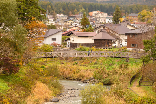 Beautiful view of Hakuba Village with the Japan Alps as a backdrop and a clear stream flowing through it in autumn, view from Oide Park, Nagano Prefecture, Japan 