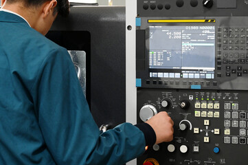 Factory workers using CNC lathe machine