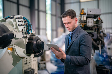 Engineer Monitors Machinery While Using Tablet in Modern Industrial Facility