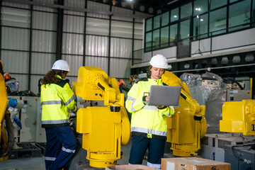 Engineers Working With Robotic Arms in a Manufacturing Facility During Daytime