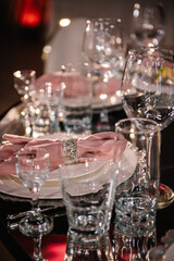 Wedding set up, dinner table reception. Plate decorated linen pink napkin and silverware cutlery, glasses. Serving, setting table. Birthday, baptism, event. Luxury silver decor. Side view. Closeup.