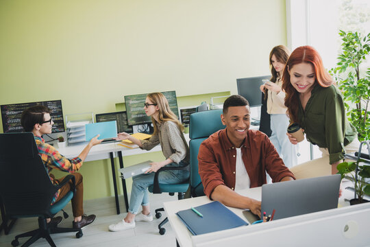 Photo of young age company colleagues diverse teamwork sitting at office with computers data analytics indoors modern location - Powered by Adobe