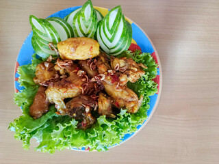 Balinese Ayam Betutu is an authentic Indonesian food from Bali. This food consisting of spicy roasted chicken, sambel matah, steamed rice and stir-fried vegetables.