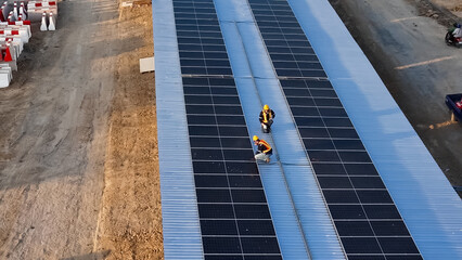 Workers Install Solar Panels on a Rooftop During Daytime Construction Activities