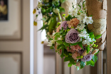 The arrangement features a delicate light purple rose and soft old pink carnations. A detail of a floral arrangement with pastel-colored flowers. 