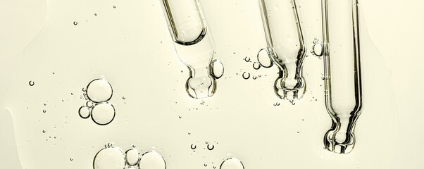 Three pipettes and a serum texture for skin with bubbles. Liquid body care product. Closeup.