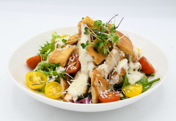 Ensalada César con pollo y verduras sobre un fondo blanco en el restaurante