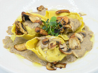 Raviolis con salsa de champiñones en plato blanco en un restaurante