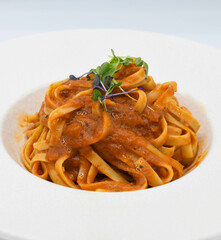 Fideos a la boloñesa con salsa de tomate en un plato blanco