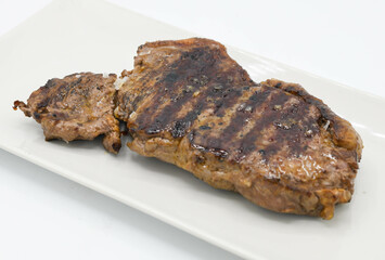 Grilled beef steak on a white plate isolated on white background.