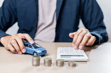 person calculates car expenses with toy car and coins