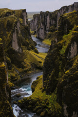 river surrounded by mossy Icelandic cliffs
