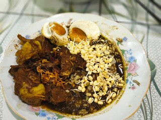 A bowl of Rawon, a rich and flavorful Indonesian beef stew.