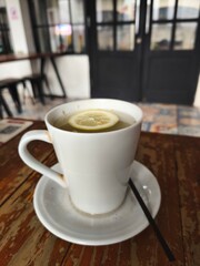 A steaming cup of hot lemon water, garnished with a lemon slice.