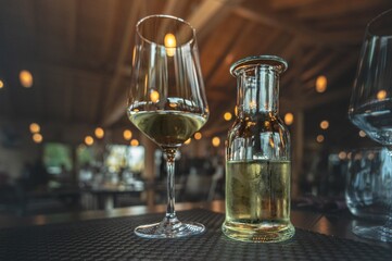Glass of White Wine with a Chilled Bottle in a Cozy Restaurant Setting