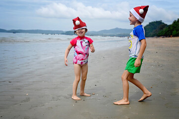 kids in Santa hat on the beach