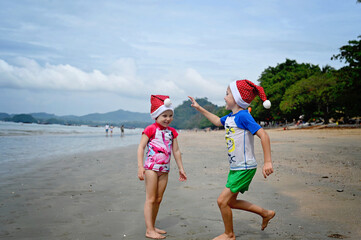 kids in Santa hat on the beach