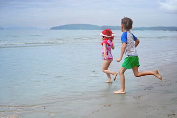 kids in Santa hat on the beach