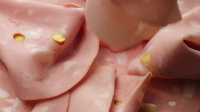 Mortadella with pistachio, rotation in circle. traditional Italian Bologna meat, Turning. classic Italian deli meat with pistachio