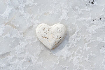 Obraz premium Heart-shaped stone placed on white snow for a romantic Valentine's Day celebration