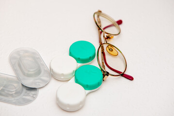 glasses, contact lenses and contact lens holder on white background