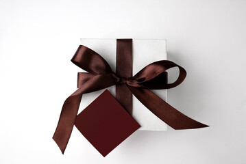 White gift box with a bow on a white background. Copy space. Place for text. Top view.