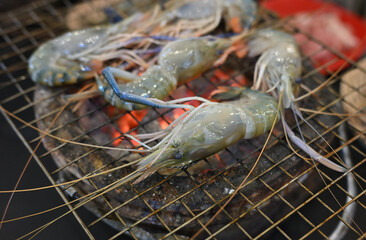 Grilling prawns on top of flaming charcoal