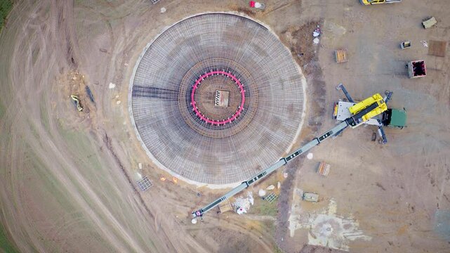 Drone video of the steel framework of a wind turbine foundation under construction, highlighting the engineering and structural base of renewable energy infrastructure. Top-down drone shot.