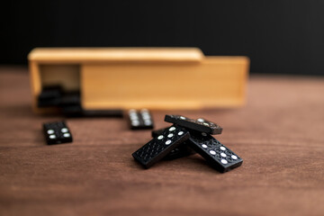 box of domino tiles on a wooden table