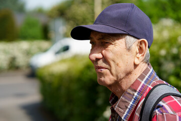 Portrait of an elderly man in a cap and plaid shirt