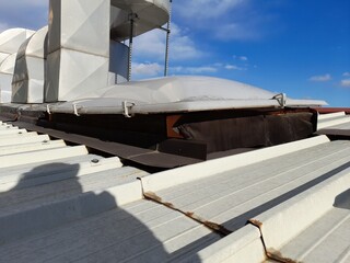 Vecchia copertura in lamiera coibentata e lucernario di un capannone industriale abbandonato con evidenti problemi di infiltrazioni per lo stato delle guaine di impermeabilizzazione