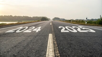 Fototapeta premium Road to 2025: New Year, New Journey - Asphalt road, years 2024 and 2025 painted, sunrise, journey, future. Represents progress, time, new beginnings and planning.