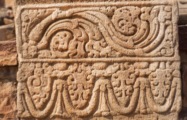 Patterned design of stone relief on wall of abandoned temple, India. 