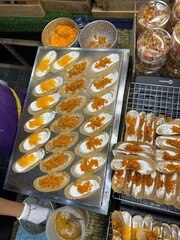 A person is carefully holding a tray of delicious food on a table