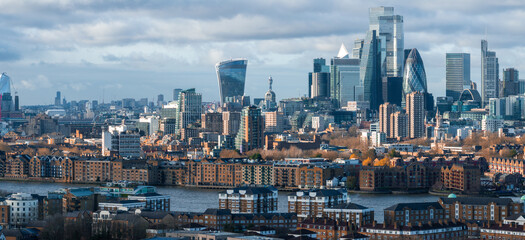 Aerial view of London's skyline featuring the Walkie Talkie, the Gherkin, and the Shard. The River Thames flows amidst modern and historic architecture.