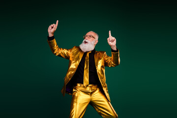 Fototapeta premium Charismatic elderly man in golden suit celebrating a joyous occasion with style against green backdrop
