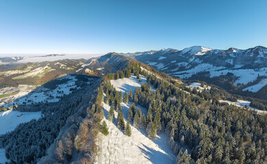 wintry panoramic aerial view of the snow covered alpine landscape of the Nagelfluh mountain chain...