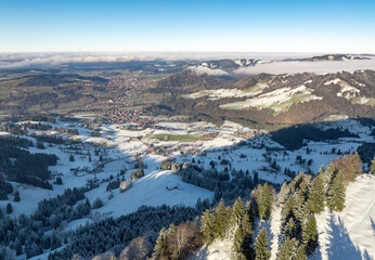 wintry panoramic aerial view of the snow covered alpine landscape with the Oberstaufen-Steibis village, Allgaeu Alps, Bavaria, Germany