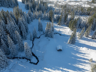 aerial photo of a little creek winding in the snowy landscape of the Hochhaedrich  mountain area in...