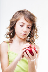 Young girl holding a red apple on white background