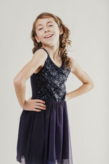 Smiling girl with sparkly dress posing with hands on hips