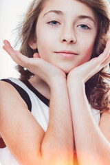 Portrait of a cute young girl gently resting her chin on her han