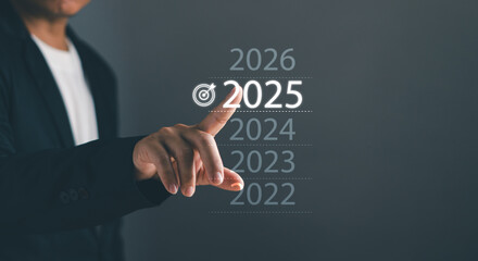 Business goal and vision for 2025.Performance goals for success Concept. Businessman touch 2025 with finger show business start up, strategies and processes for organization operations in new year
