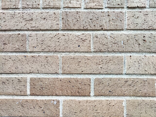 Textured brick wall with neutral tones suitable for backgrounds or framing for various design purposes