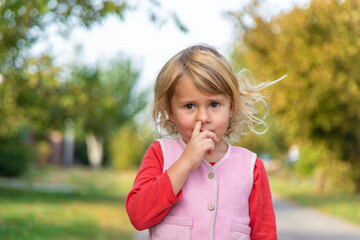 Fototapeta premium A child picks his nose with his finger. Selective focus.